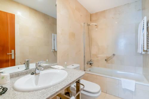 a bathroom with a sink and a toilet and a tub at Ponferrada Plaza in Ponferrada
