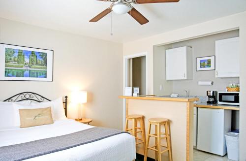 a bedroom with a bed and a kitchen at Sierra Mountain Inn in Grass Valley