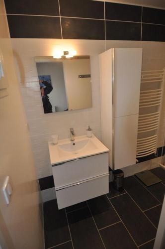 une salle de bain avec un lavabo blanc et un miroir dans l'établissement Villa familiale piscine-Océan & Bassin d'Arcachon, à Le Porge
