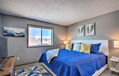 a bedroom with a blue bed and a window at Welcoming West Fargo Retreat w Backyard in West Fargo