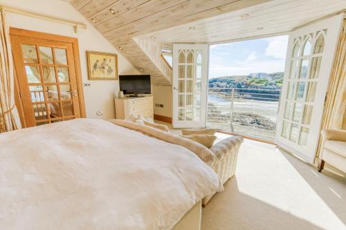 a bedroom with a large bed and a large window at Pen y Graig in Rhoscolyn