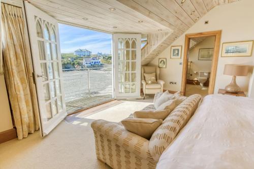 a bedroom with a bed and a couch and a window at Pen y Graig in Rhoscolyn