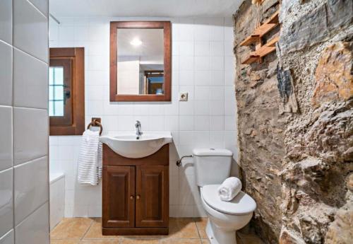 a bathroom with a white toilet and a sink at Molino del Nacimiento in Laujar de Andarax