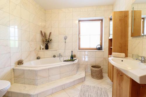 a bathroom with a tub and a sink and a toilet at Naturtalente Berghaus - Apartment 4 in Innerschwand am Mondsee