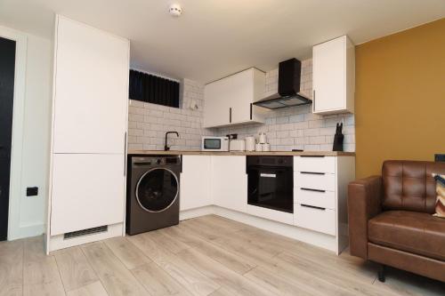 a kitchen with a washer and dryer in a room at The Oasis Apartment in Leeds