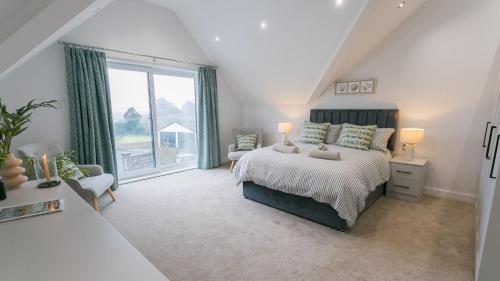 a bedroom with a bed and a large window at Sirusa in Trearddur