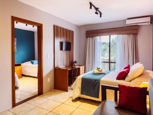 Luzzy Hotel في كانيلا: غرفة فندقية بسريرين ومرآة