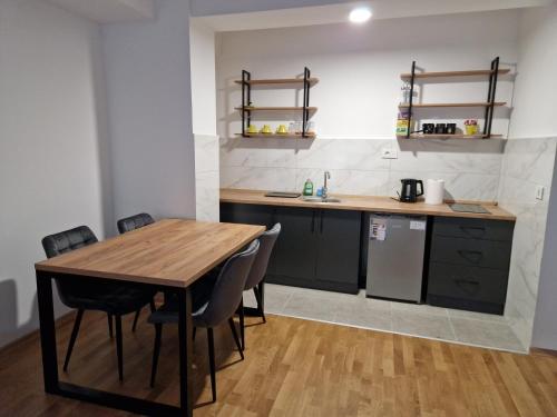 a kitchen with a wooden table and chairs in a room at Luxury Apartment IVA III in Skopje