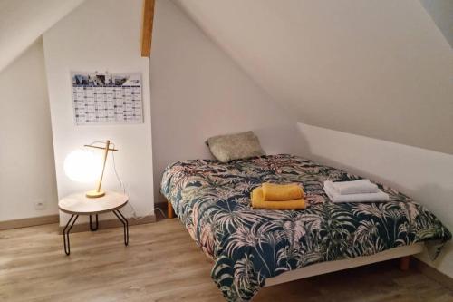 a bedroom with a bed and a lamp and a table at GOOD HOME Chez Lulu, plage & centrale in Gravelines