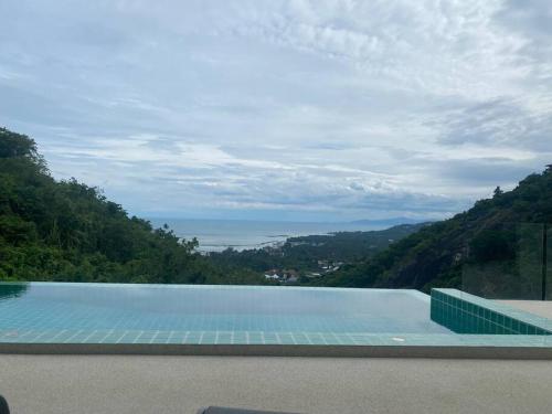 een groot zwembad met uitzicht op de oceaan bij Villa Staring at the sea 3/4 ch jacuzzi piscine in Koh Samui 