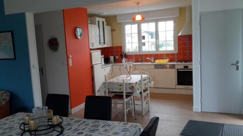 une cuisine avec une table et une cuisine aux murs rouges dans l'établissement maison de l ile, à Damgan