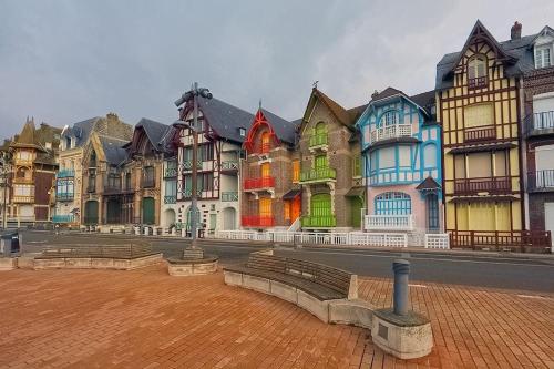 une rangée de maisons colorées sur le côté d'une rue dans l'établissement L'échappée MERs- Maison 3 chambres au Centre 500m de la plage, à Mers-les-Bains