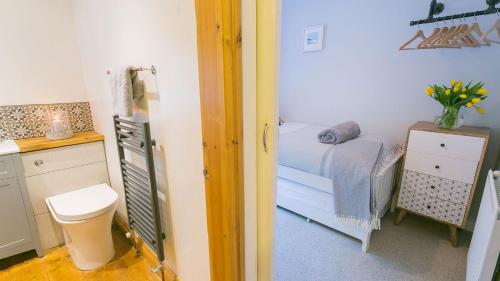 a small room with a bed and a bathroom at Cuddfan in Llanberis