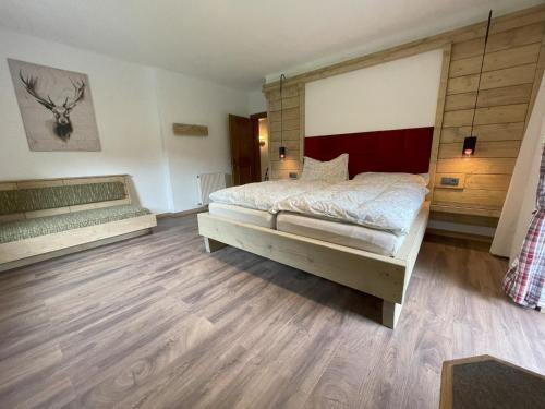 ein Schlafzimmer mit einem großen Bett und Holzböden in der Unterkunft Ferienwohnung Lisal in Mutters