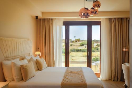 a bedroom with a large bed and a large window at Santa Lucia Boutique Hotel in Santa Luċija
