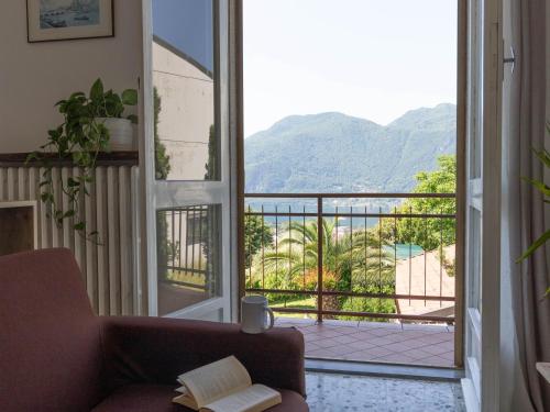 a living room with a couch and a view of a balcony at Mamma Ciccia Holiday Home - Mountains & Lake in Mandello del Lario