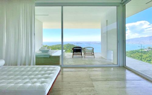 a bedroom with a bed and a view of the ocean at Encanto Acapulco in Acapulco