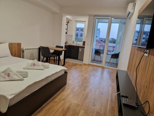 a bedroom with a bed and a table with chairs at Luxury Apartment IVA III in Skopje