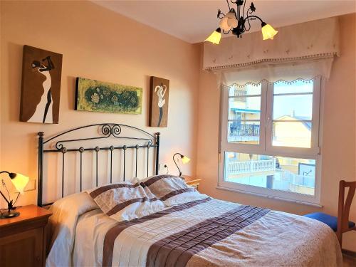 a bedroom with a bed and a window at Apartamentos SOL Y PLAYA Foz in Foz