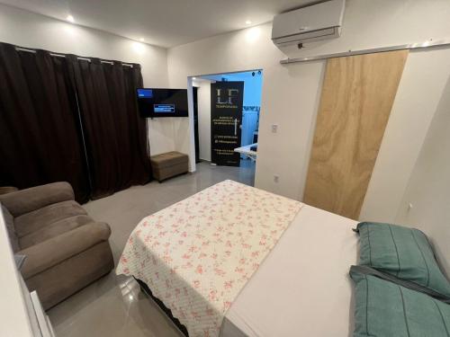 um quarto com uma mesa, uma cadeira e uma televisão em Pontal do Atalaia 28 em Arraial do Cabo