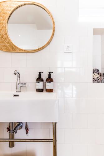 une salle de bain avec un lavabo et un miroir dans l'établissement Mer nature, appartement spacieux by Les Filles du Bord de Mer, petite terrasse vue mer, à Port-en-Bessin-Huppain