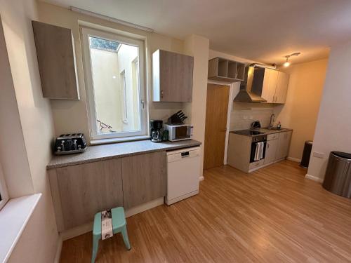 a small kitchen with a counter and a window at North London A spacious 7 bedroom house accommodating up to 18 people complete with own gym and table tennis in London