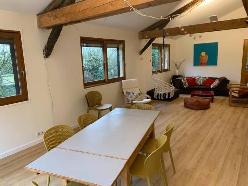 sala de estar con mesa blanca y sillas en Maison de famille au vert classée 3 étoiles, en Les Andelys