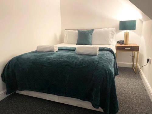 een slaapkamer met een groot bed en een groene deken bij Home in Bridgwater