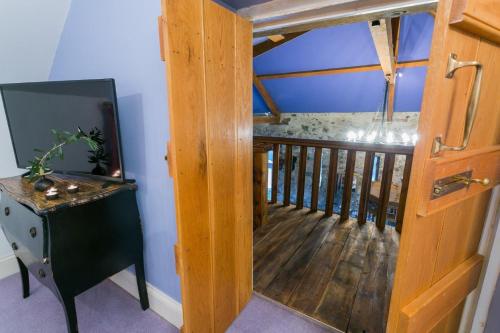 a room with a wooden door leading to a balcony at Tal Y Bont Uchaf Courtyard in Bangor