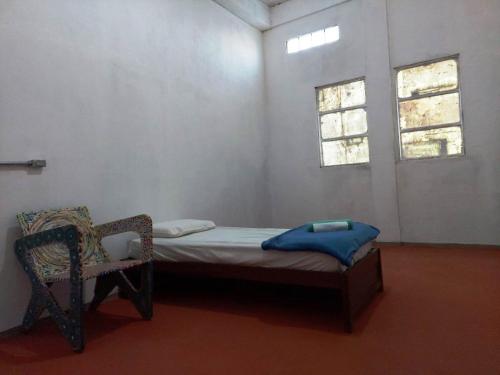 mały pokój z łóżkiem i krzesłem w obiekcie Pousada Vila da Serra - Quarto Sabiá w mieście Nova Lima