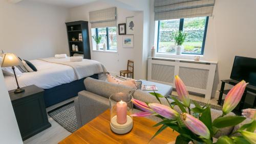 a living room with a bed and a couch and a table at The Old Abbey in Trearddur