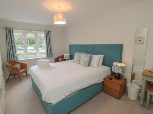 1 dormitorio con 1 cama grande y cabecero azul en Quayside Haven en Whitby