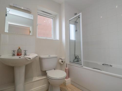 a white bathroom with a toilet and a sink at Quayside Haven in Whitby
