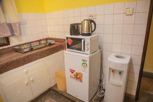 een kleine keuken met een magnetron bovenop een koelkast bij Asya Homes in Mombasa