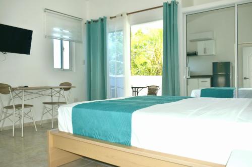 a bedroom with a bed and a table and a window at Tropical Casa Laguna in Cabarete