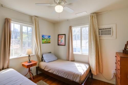 1 dormitorio con 2 camas y 2 ventanas en Eclectic Oroville Cottage with Charcoal Grill!, en Oroville