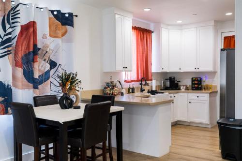 a kitchen with white cabinets and a table and chairs at The Relyn in Inglewood