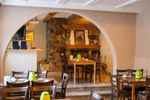 فندق ألبينهوف في اوبيرو: غرفة طعام بها طاولات وكراسي وجدار حجري