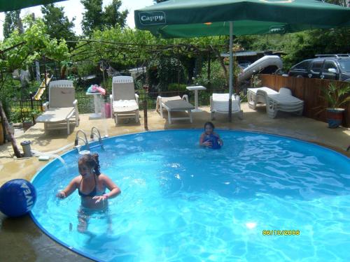 dos niños jugando en una gran piscina en Villa Trakia, en Golden Sands