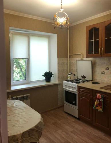 uma cozinha com um fogão e uma janela em 1 комн. квартира на Есет батыра em Aqtöbe