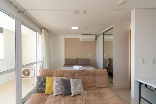 um quarto com uma cama e um sofá num quarto em Brookfield Tower - BFT em Goiânia