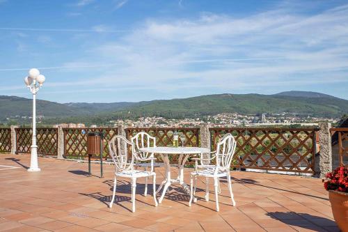 a patio with a table and chairs on a balcony at TERRA de Lestrove - Quality Rooms in Padrón