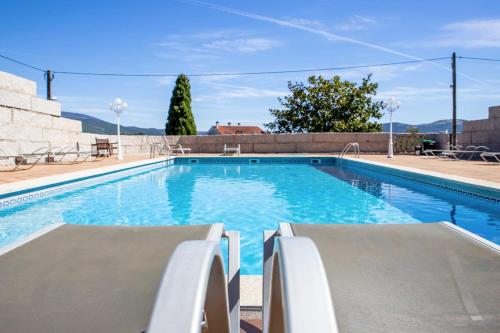 a large swimming pool with blue water at Hotel Terra in Padrón