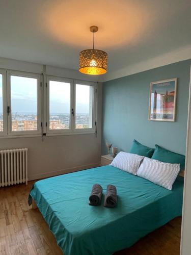 une chambre avec un lit avec deux pantoufles dessus dans l'établissement Les toits de Toulouse - T3 & GARAGE, à Toulouse