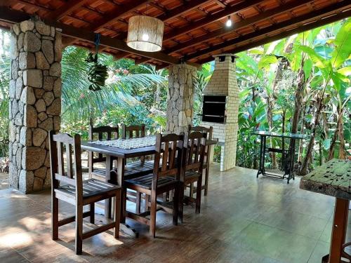 a wooden table and chairs on a patio at Casa da Ilha Paraty Entre a mata atlântica e o mar in Paraty