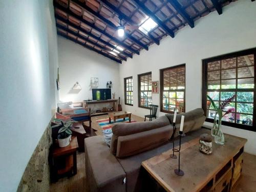 a living room with a couch and a table at Casa da Ilha Paraty Entre a mata atlântica e o mar in Paraty