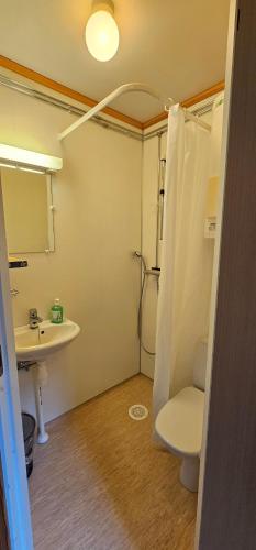 La salle de bains est pourvue de toilettes, d'un lavabo et d'une douche. dans l'établissement Gamvik brakkebo as, à Gamvik