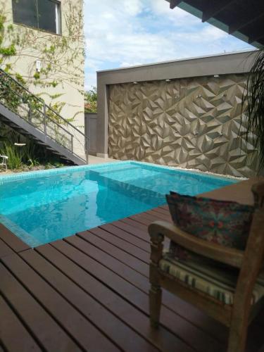 a swimming pool with a bench next to a building at Casa Temporada Castro Alves in Bonito