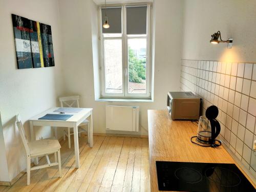 een keuken met een tafel en een tafel en een raam bij Kazimierz/Old Town Apartment in Krakau