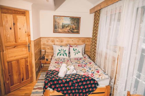 niewielka sypialnia z łóżkiem i oknem w obiekcie Willa Szarotka w Rabce